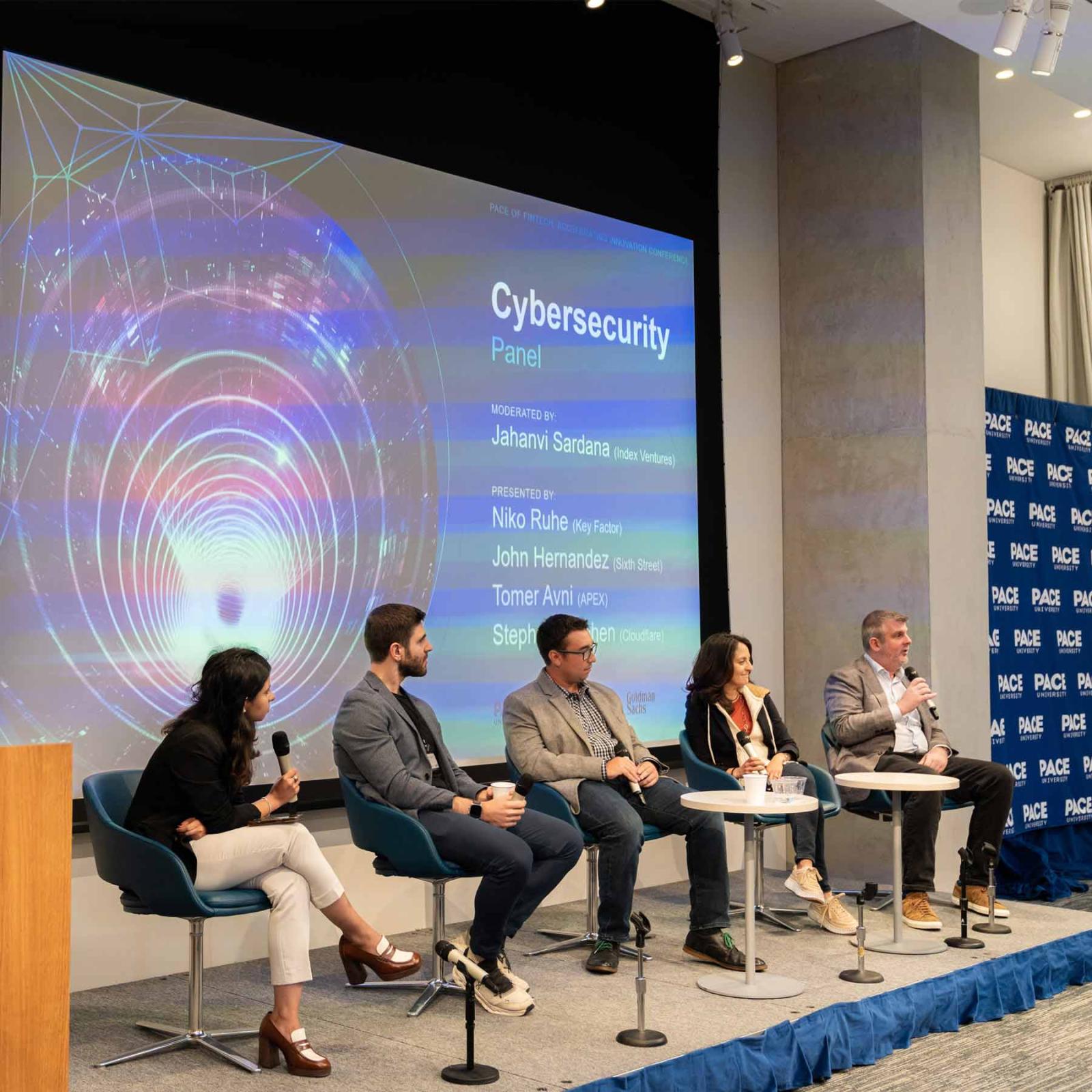 People on stage at a panel for the FinTech conference.