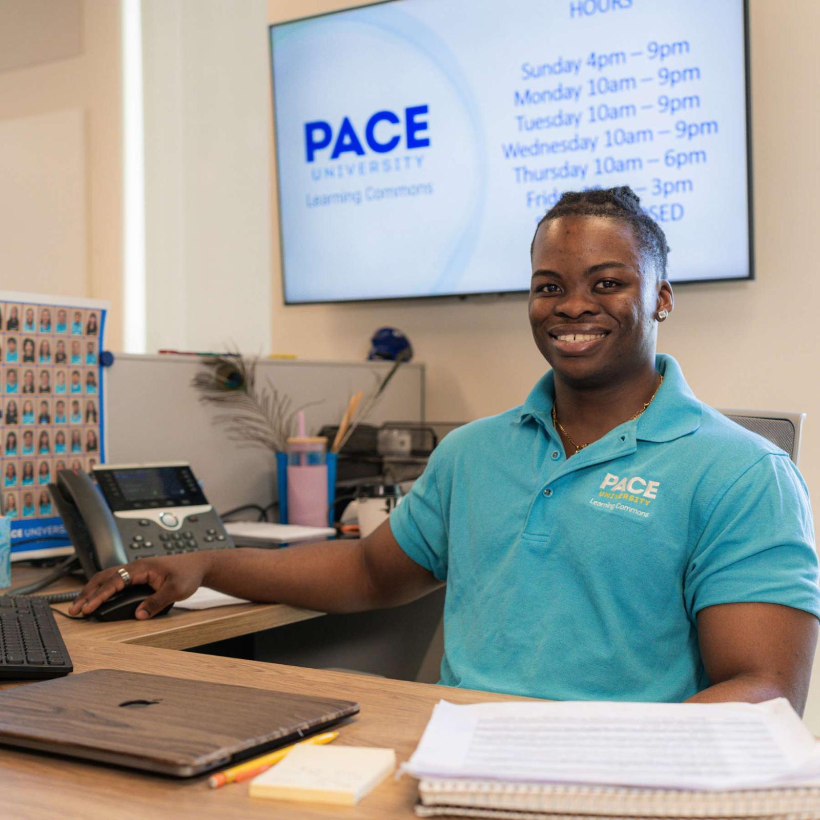 Pace University student working at the front desk of the Learning Commons