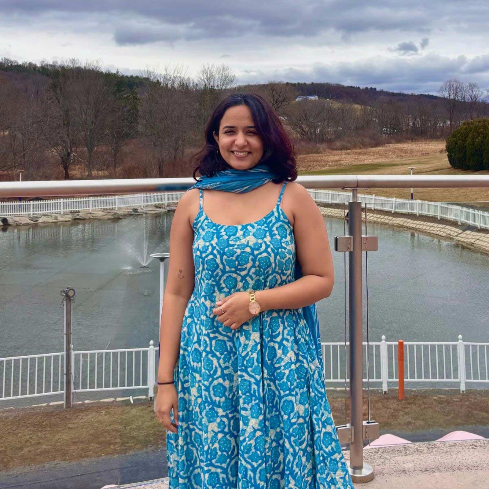 Seidenberg student Riya Golani smiling for a photo in front of a lake in nature.