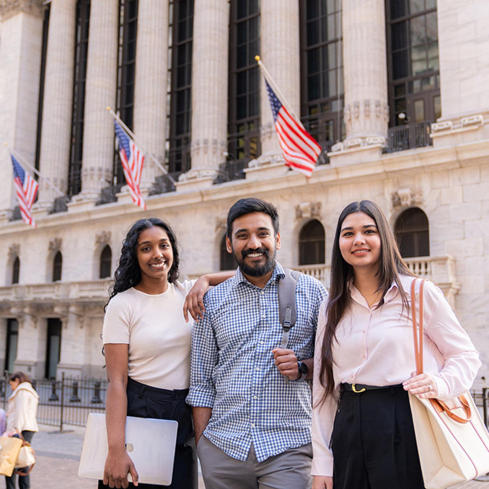Three Pace Lubin graduate students walking on Wall Street in Lower Manhattan.