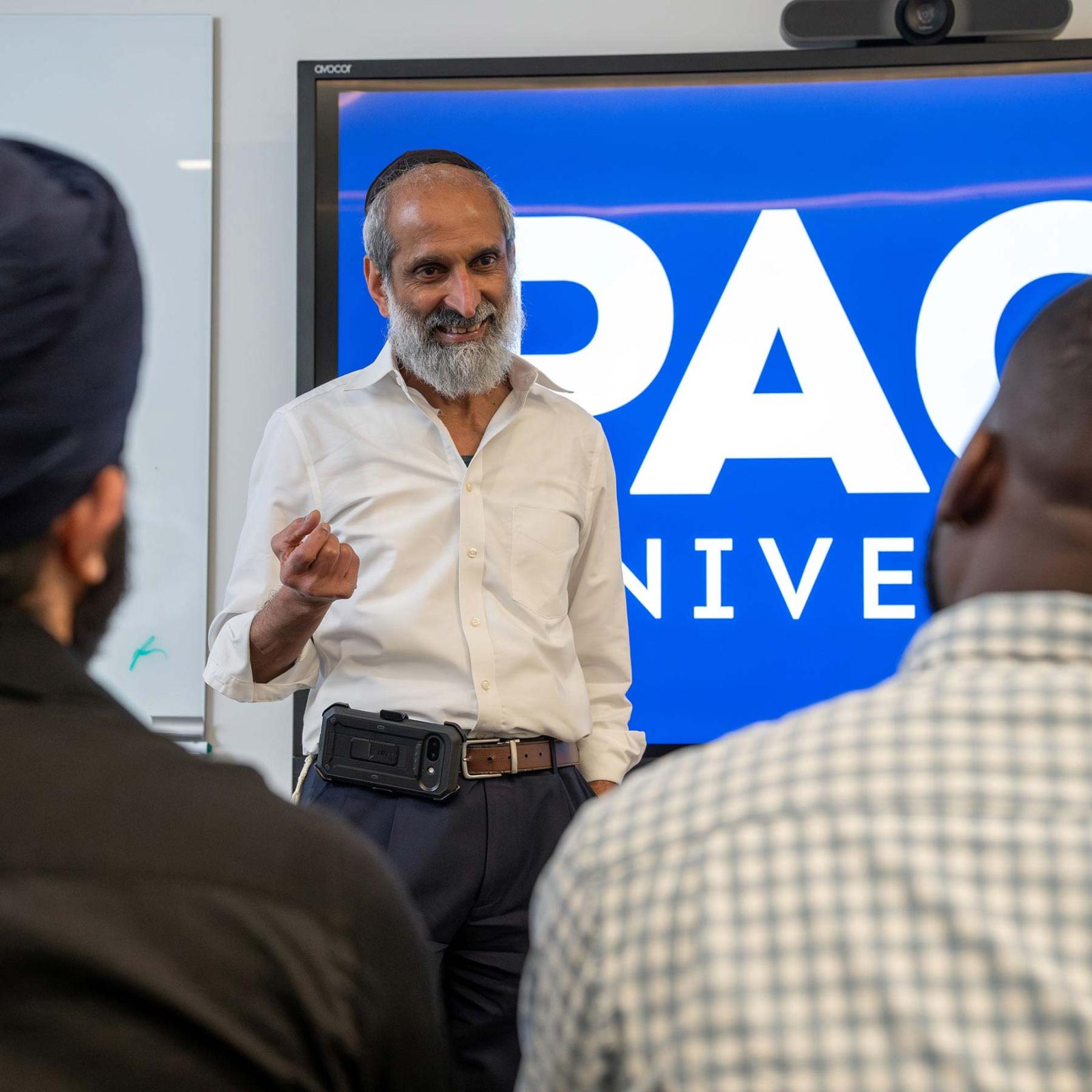 finance professor P.V. Viswanath teaching students in a classroom at One Pace Plaza