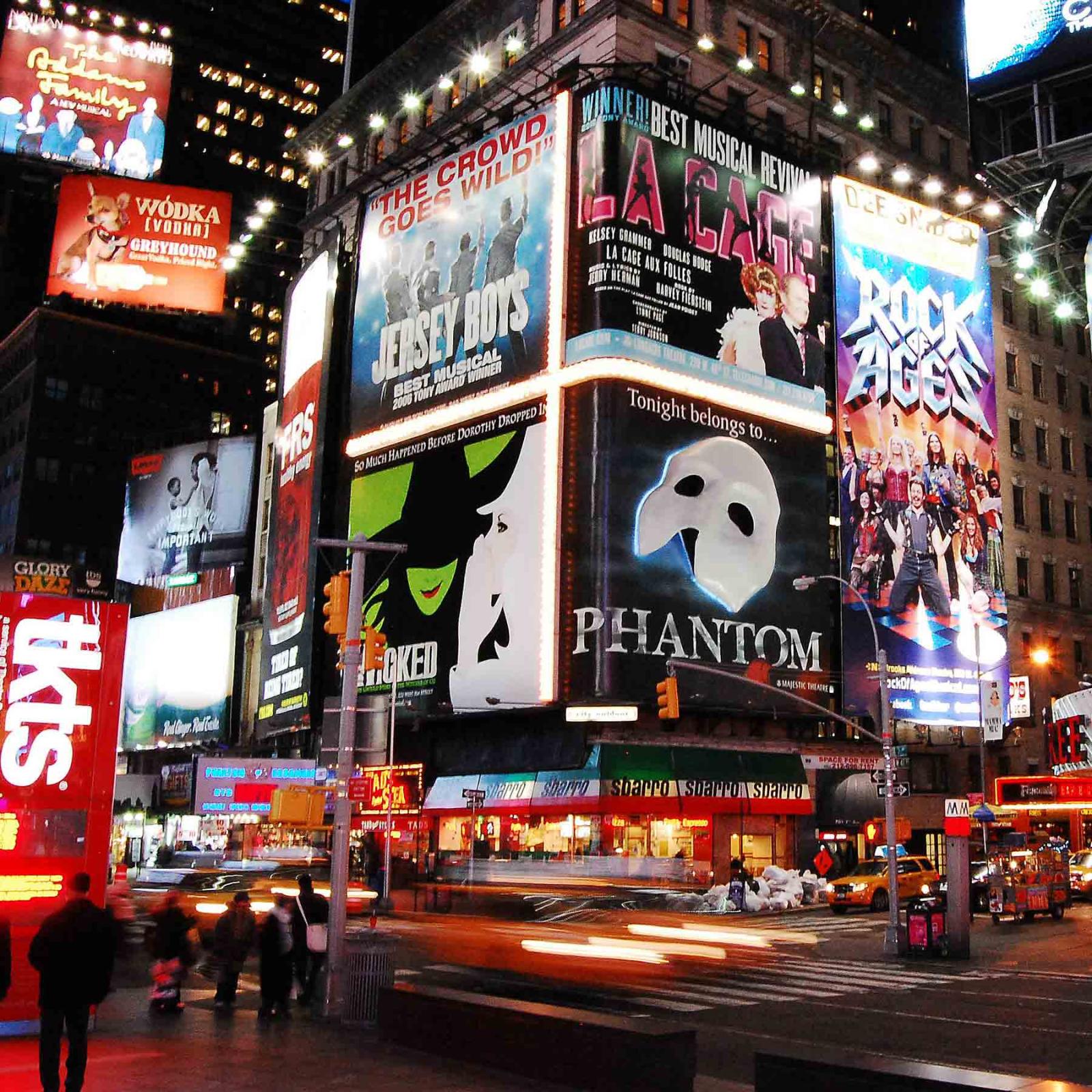 NYC and Broadway at night with marquees for major Broadway performances.