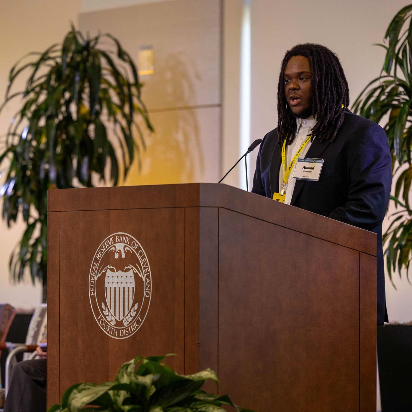 Pace University Economics student at podium presenting at Economic Scholars Program