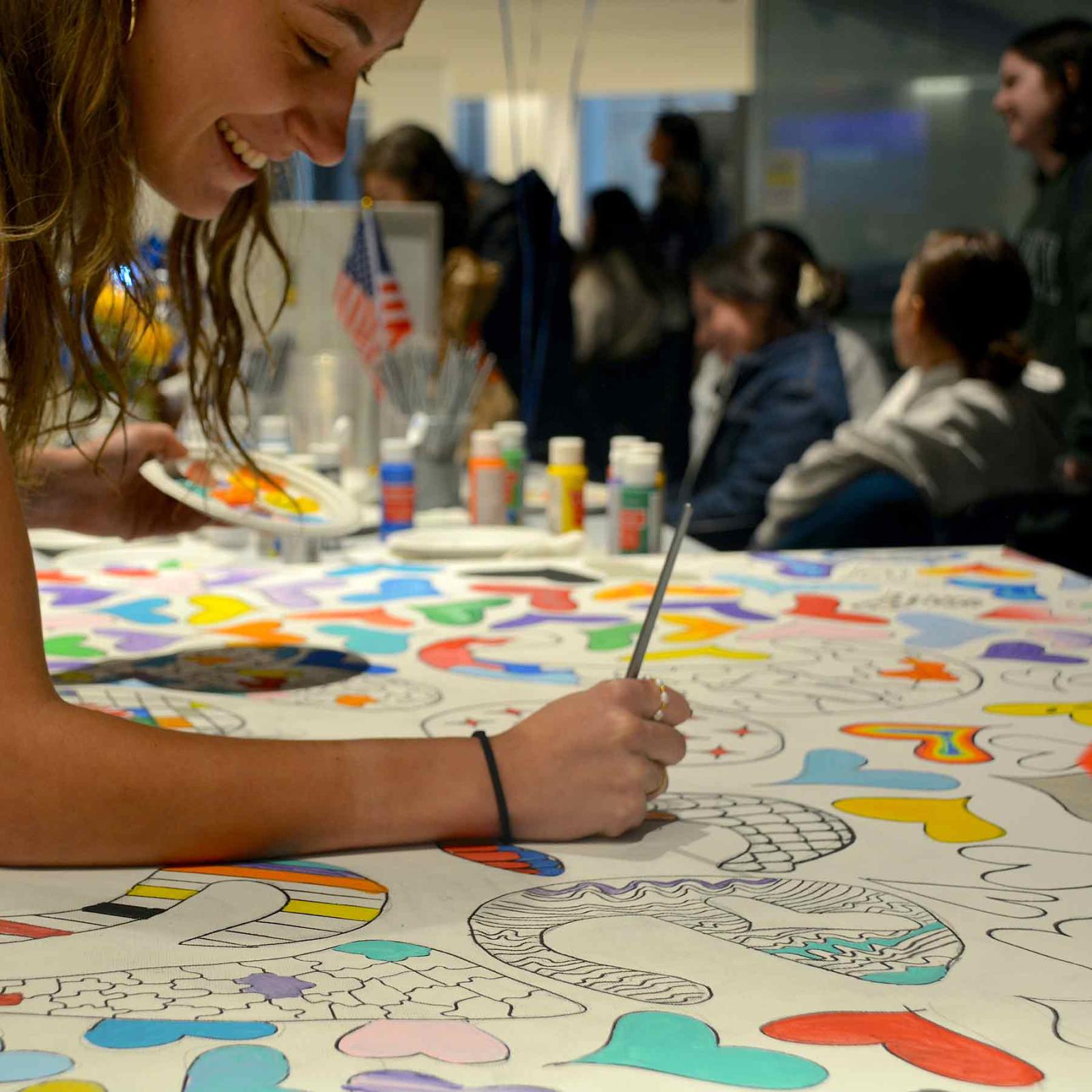 A Pace University student coloring a voter engagement banner