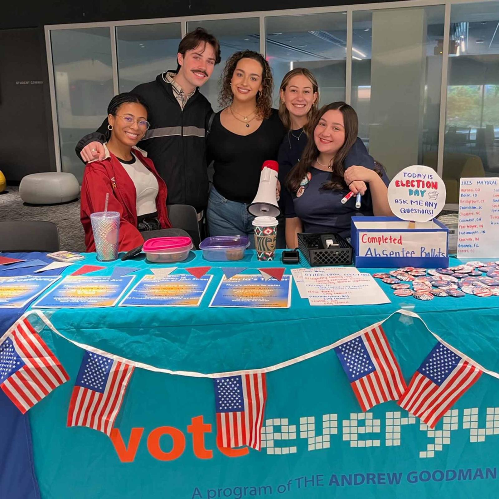 Pace University students standing at a table with election and voter information