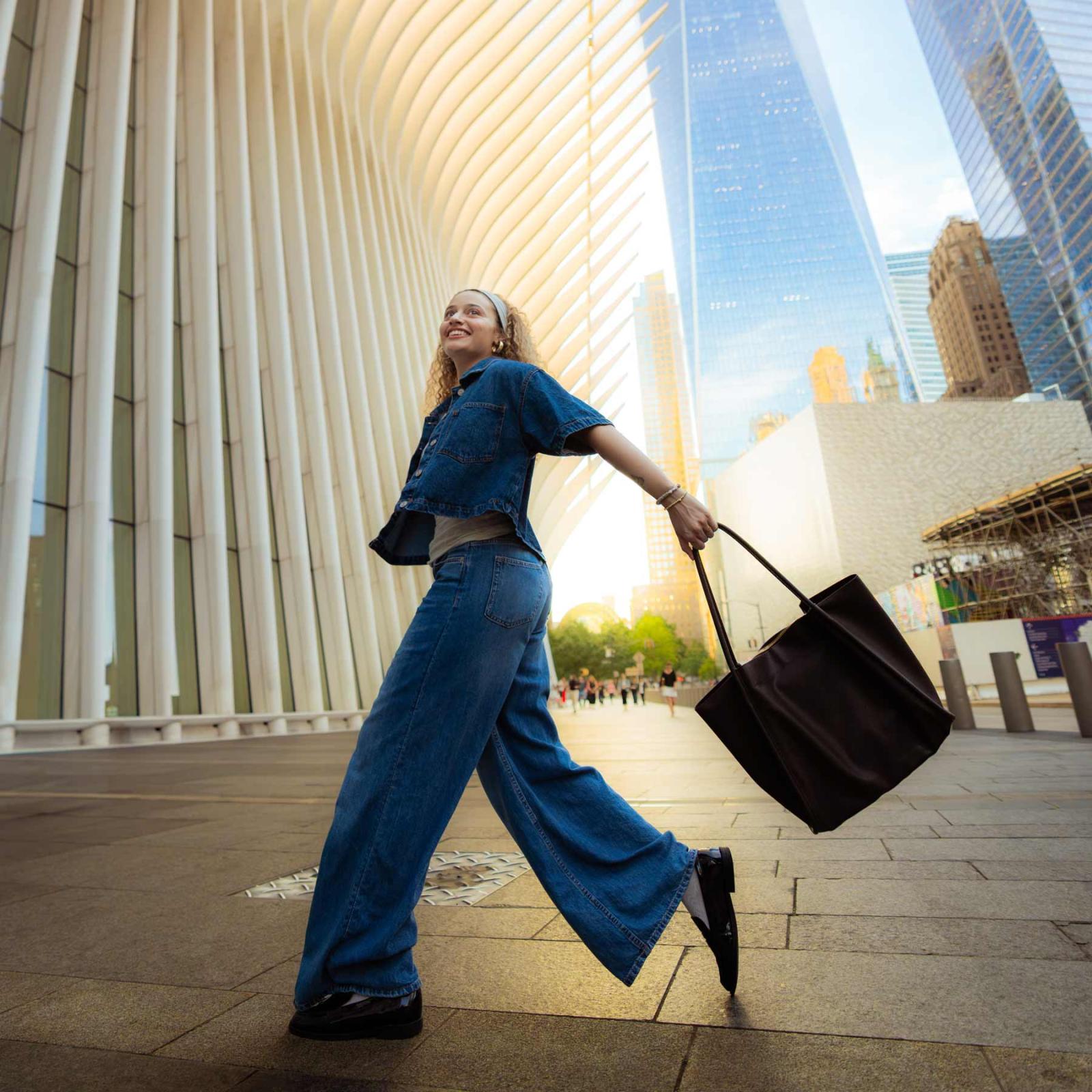 Pace University student walking in NYC, holding a bag.