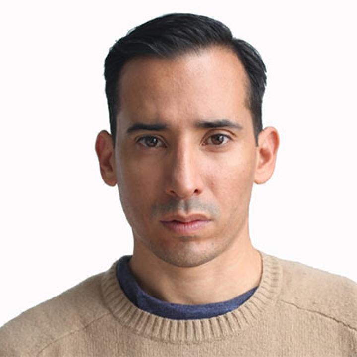 Portrait of JC Vasquez wearing a tan sweater