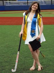 Morgan Strecker posing on the athletic field with her field hockey stick.
